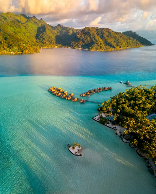 Aerial view of overwater bungalows in a turquoise lagoon