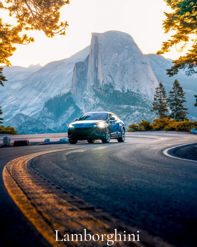 Lamborghini: Blue Lamborghini Urus on a curving road below Half Dome, Yosemite, at golden hour