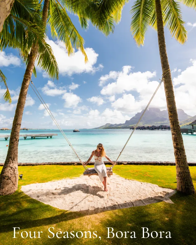 Four Seasons Bora Bora: Woman in white on a swing between palm trees above the Bora Bora lagoon
