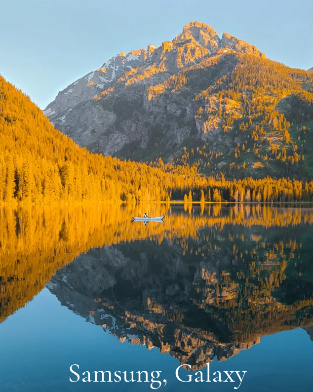 Samsung Galaxy: Mountain lake reflecting golden larches, with a small boat