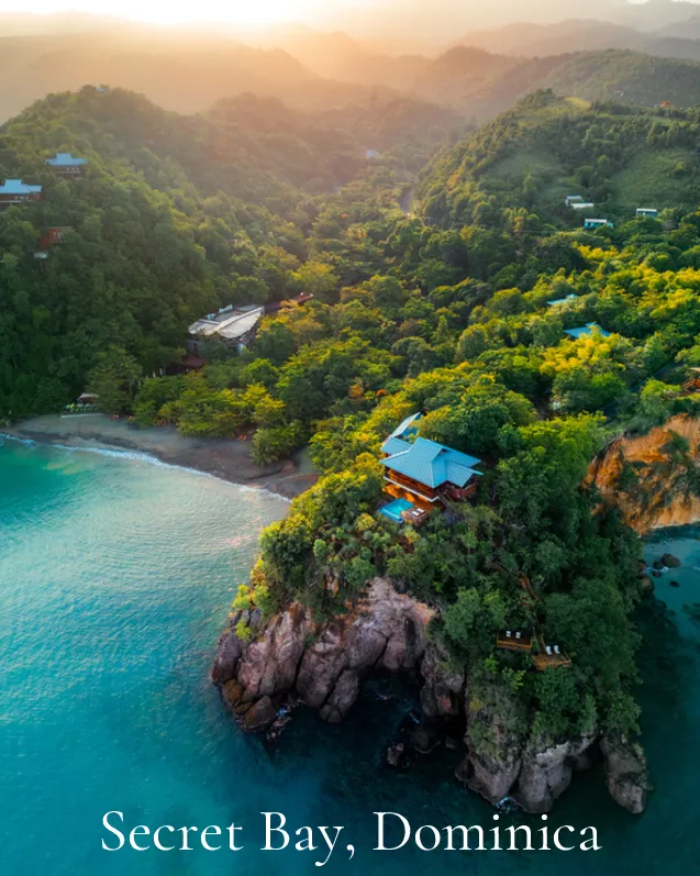 Secret Bay, Dominica: Aerial view of a jungle headland with villas above turquoise water